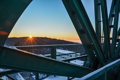 Picture of a sunset in winter, photographed through a big metal wheel