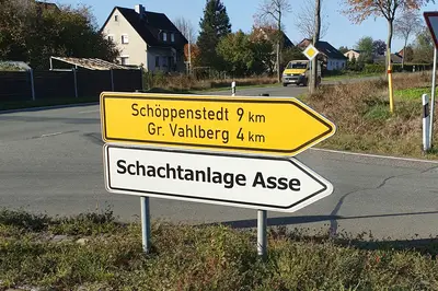 Zwei Straßenschilder zeigen beide in die gleiche Richtung, eines weist den Weg einer Bundesstraße, das andere weist den Weg zur Schachtanlage Asse