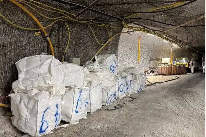 Foto von großen weißen und befüllten Säcken in einer Strecke unter Tage in einem Salzbergwerk.