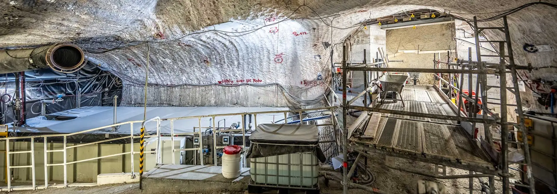 Ein unterirdischer Hohlraum, in dem sich ein großes Speicherbecken befindet. Daneben finden Bauarbeiten statt.