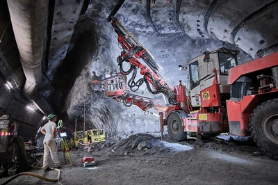 Ein Bergmann im Bergwerk Konrad vor einer Ankerbohranlage