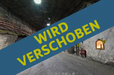 Schriftzug "Wird verschoben" in Großbuchstaben, Bergwerk im Hintegrund