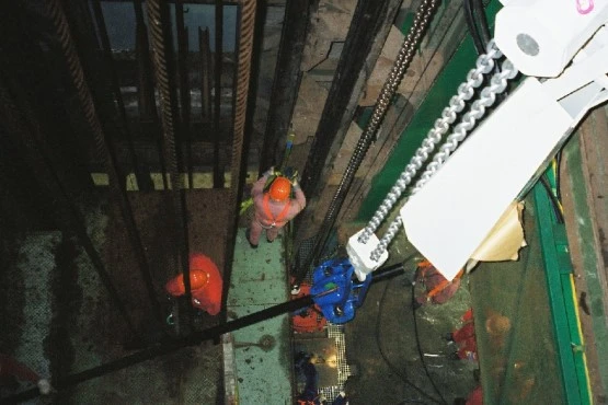 Workers install a vertical pipe for transporting salt concrete within the Bartensleben shaft cylinder