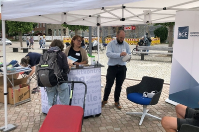 Eine Frau erkundigt sich an einem Informationsstand.