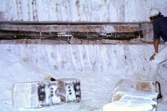 Metal parts in a longitudinal cut hole in a salt block.