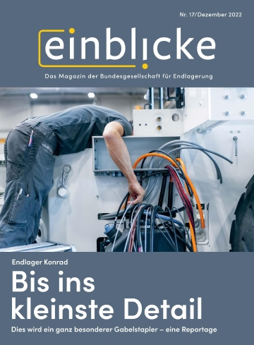 Das Cover des Einblicke Magazins 17 zeigt einen Mechaniker, der an einer Maschine arbeitet. Sein Kopf verschwindet dabei im Rumpf der Maschine, im Vordergrund befinden sich dicke Kabel.