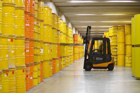 A forklift truck transports a drum of radioactive waste