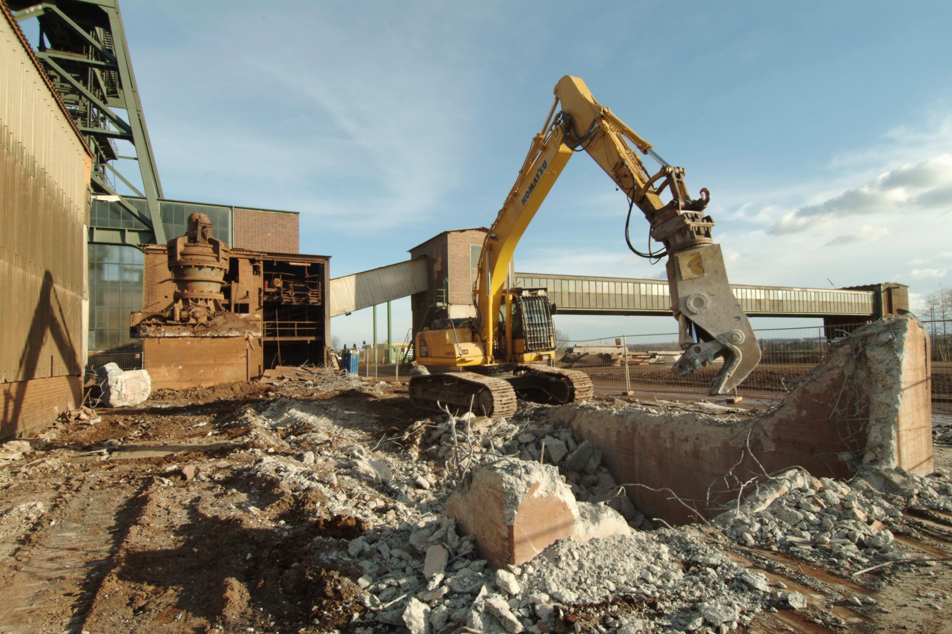 Ein Bagger trennt mit einer hydraulischen Schere Stahlbewehrung aus einem Betonfundament