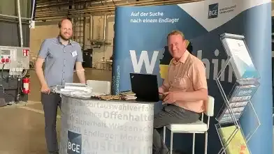 Zwei Männer am Stand der BGE beim Forum Endlagersuche.