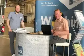 Zwei Männer am Stand der BGE beim Forum Endlagersuche.