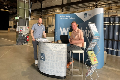 Zwei Männer am Stand der BGE beim Forum Endlagersuche.