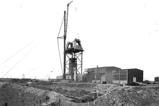 The historical photograph shows assembly work on the winding tower of Konrad 1