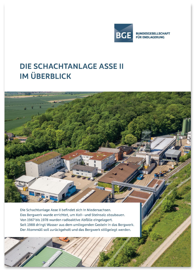 Das Cover der Asse-Broschüre zeigt die Schachtanlage Asse II aus der Vogelperspektive: Eine Industrieanlage mit mehreren Gebäuden umrahmt von Bäumen und Feldern bei Sonnenschein.